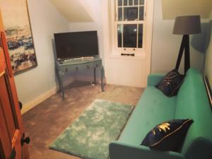 ポートラッシュにあるThe Carrickのリビングルーム(緑のソファ、テレビ付)