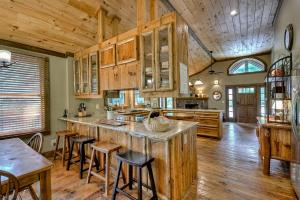 a kitchen with wooden cabinets and a large island with bar stools at Creektopia in Blue Ridge