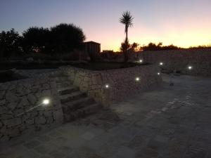 un muro di pietra con scale e una palma al tramonto di Madonna delle Grazie a Laterza