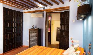 Zimmer mit einem Bett und einem Zimmer mit einer Tür in der Unterkunft Casilla Dalea en Carcabuey, descubre el interior de Andalucia in Carcabuey