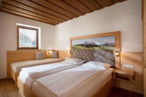 a bedroom with two beds and a painting on the wall at Appartementhaus Fuchs in Itter