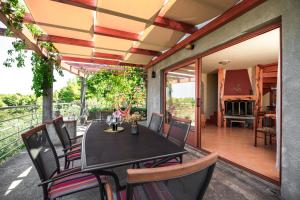 jadalnia ze stołem i krzesłami na patio w obiekcie Holiday home Maslinova w mieście Vela Luka