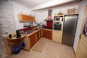 a kitchen with wooden cabinets and a stainless steel refrigerator at La Maison du Pescadou Gruissan Village-Autentique-Plage in Gruissan