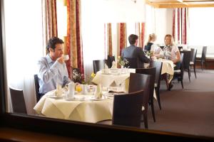 eine Gruppe von Personen, die in einem Restaurant an Tischen sitzen in der Unterkunft Hotel Falken in Memmingen