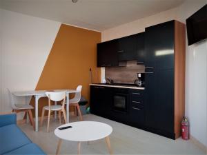a kitchen with a blue couch and a table at Stella Plage Les Lierres in Stella-Plage