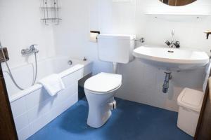 a white bathroom with a toilet and a sink at Appartementhaus Huber in Abersee +44 photos