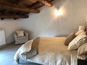 um quarto com uma cama grande e uma cadeira em Casa Antica em Santo Stefano di Sessanio