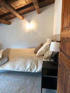 um quarto com uma cama e uma mesa com um candeeiro em Casa Antica em Santo Stefano di Sessanio