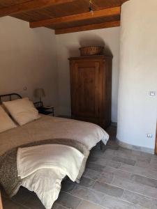 een slaapkamer met een bed en een houten kast bij Casa Antica in Santo Stefano di Sessanio