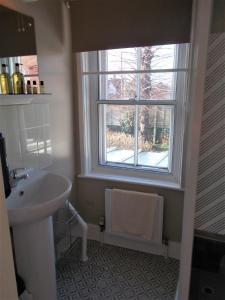 baño con lavabo y ventana en The Beaumont en Sittingbourne