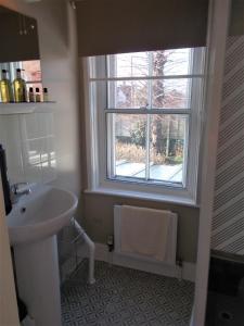 baño con lavabo y ventana en The Beaumont, en Sittingbourne