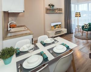 uma sala de jantar e sala de estar com mesa e cadeiras em Relax apartments near Egle em Druskininkai