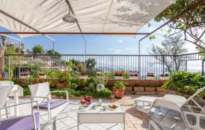 ナポリにあるCasa Rosa - Sea View & Terrace Apartmentのパティオ(白い椅子、テーブル、大きなパラソル付)