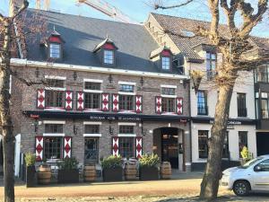 un edificio con arcos rojos y blancos en la parte delantera en Hotel De Jachthoorn en Hoogstraten