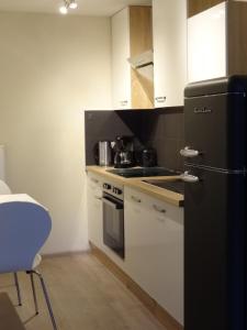 een keuken met een zwarte koelkast en witte kasten bij Ferienwohnung Eulenloch in Nördlingen