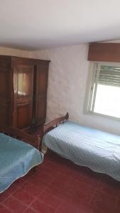um quarto com 2 camas e uma cómoda e uma janela em Casa en Mayú Sumaj a metros del Río. em San Antonio de Arredondo