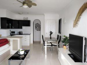 sala de estar con mesa y cocina en Apartamento La Palmera Amarilla Golf, en San Miguel de Abona