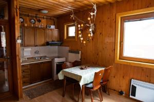 a kitchen with a table and chairs and a window at Chata Pohoda pri Jánošíku in Terchová