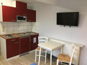 a small kitchen with a table and a tv on the wall at FEWO Appartement 4 in Minden