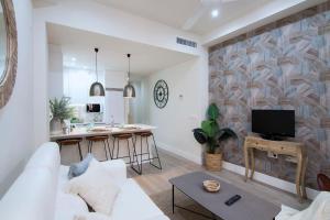 グラナダにあるCentral Deluxe Apartments by Apolo Homesのリビングルーム(白いソファ付)、キッチンが備わります。