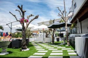 a walkway with trees and tables and umbrellas at Quintinha dos Queiroses in Vila Boa de Quires