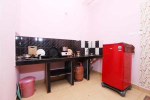 a kitchen with a counter and a red refrigerator at Morjim Sunset Guesthouse - 300 meter to Morjim Beach in Morjim