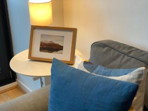 a living room with a blue couch and a table at The Heights - River and City View in Glasgow