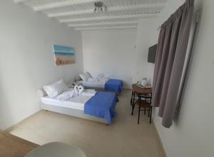 DexamenesMaya Apartments的客房设有两张床、一张桌子和一张书桌
