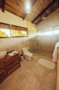 a bathroom with a toilet and a sink and a shower at Drake Bay Greenleaf in Drake