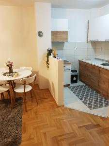 a kitchen with a table and a small kitchen with a table and chairs at Sunrise apartman in Bijeljina