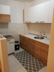 a kitchen with white cabinets and a sink at Sunrise apartman in Bijeljina