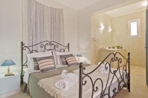 a white bedroom with a bed with towels on it at Kalimera Karpathos Exclusive Villas in Afiartis