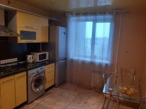 リャザンにあるЦентр Горького 32 Семейные Апартаментыのキッチン(洗濯機付)、窓が備わります。