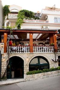 un edificio con balcone e posti a sedere di Guesthouse Sidro a Ulcinj