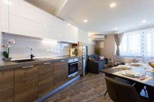 a kitchen and living room with a table and a dining room at Sedra Home in Brela