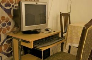 um monitor de computador e um teclado e rato numa secretária em Eleven Bed & Breakfast em Nova Deli