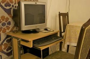 a computer monitor and a keyboard and mouse on a desk at Eleven Bed & Breakfast in New Delhi