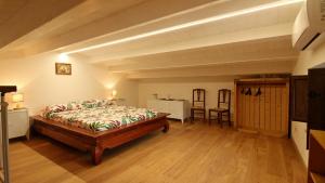 a bedroom with a bed and a wooden floor at casa tre noci in Lascari