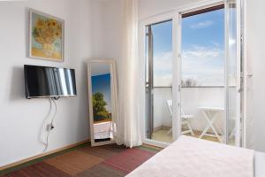 a bedroom with a bed and a mirror and a window at Apartments Pilicari in Rovinj