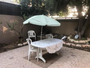 a table with two chairs and an umbrella at הבית בגן in Gan Yavne