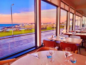 a restaurant with tables and chairs with a view of the ocean at Bayview Hotel in Bushmills
