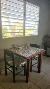 a table and chairs in a room with a window at Peña's Palalace Mayagüez in Mayaguez