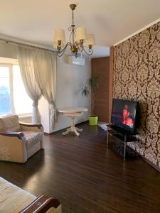 a living room with a tv and a couch and a table at Great apartment in the city centre in Ivano-Frankivsʼk