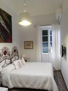 a white bedroom with a white bed and a window at DORA AUREA in Levanto
