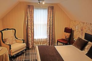 a hotel room with a bed and a chair and a window at Muthu Belstead Brook Hotel in Ipswich