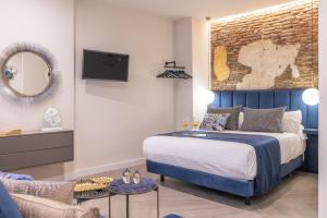 馬拉加的住宿－Spa del Palacete，一间卧室配有一张床、一台电视和一张沙发