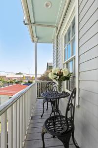 a table on a balcony with a vase of flowers at Montgomery House in New Orleans