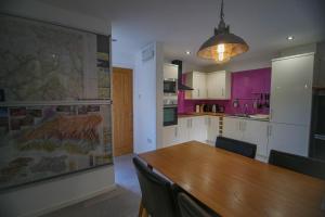 una cocina con una mesa de madera y un mapa grande en la pared en Canyon Cottage, en Pont-Nedd-Fechan