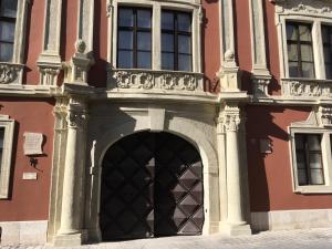 uma entrada para um edifício com uma porta grande em Enjoy Apartman em Sopron