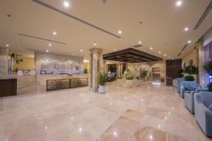 a lobby of a hospital with blue chairs at Rollins Hotel in Buraydah